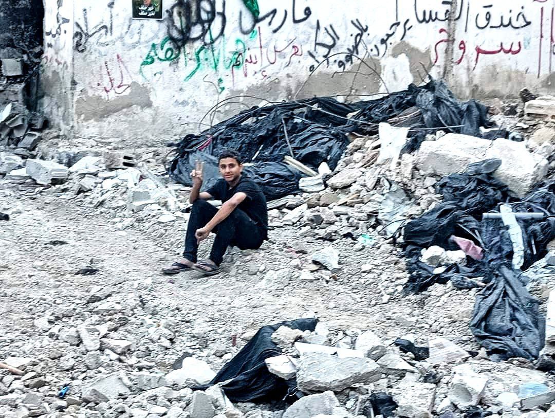 فتى فلسطيني يرفع شارة النصر بين الركام والدمار الذي حل…