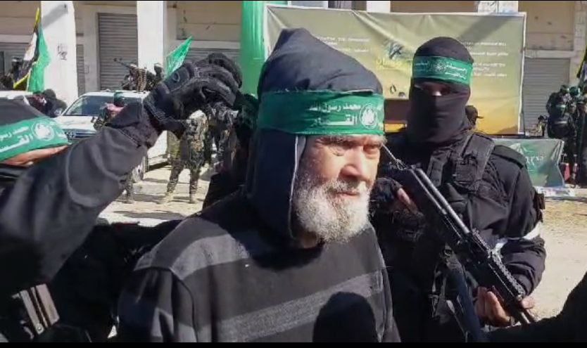 مسن فلسطيني يرتدي عصبة القسام خلال حضوره تسليم الأسيرات المجندات…